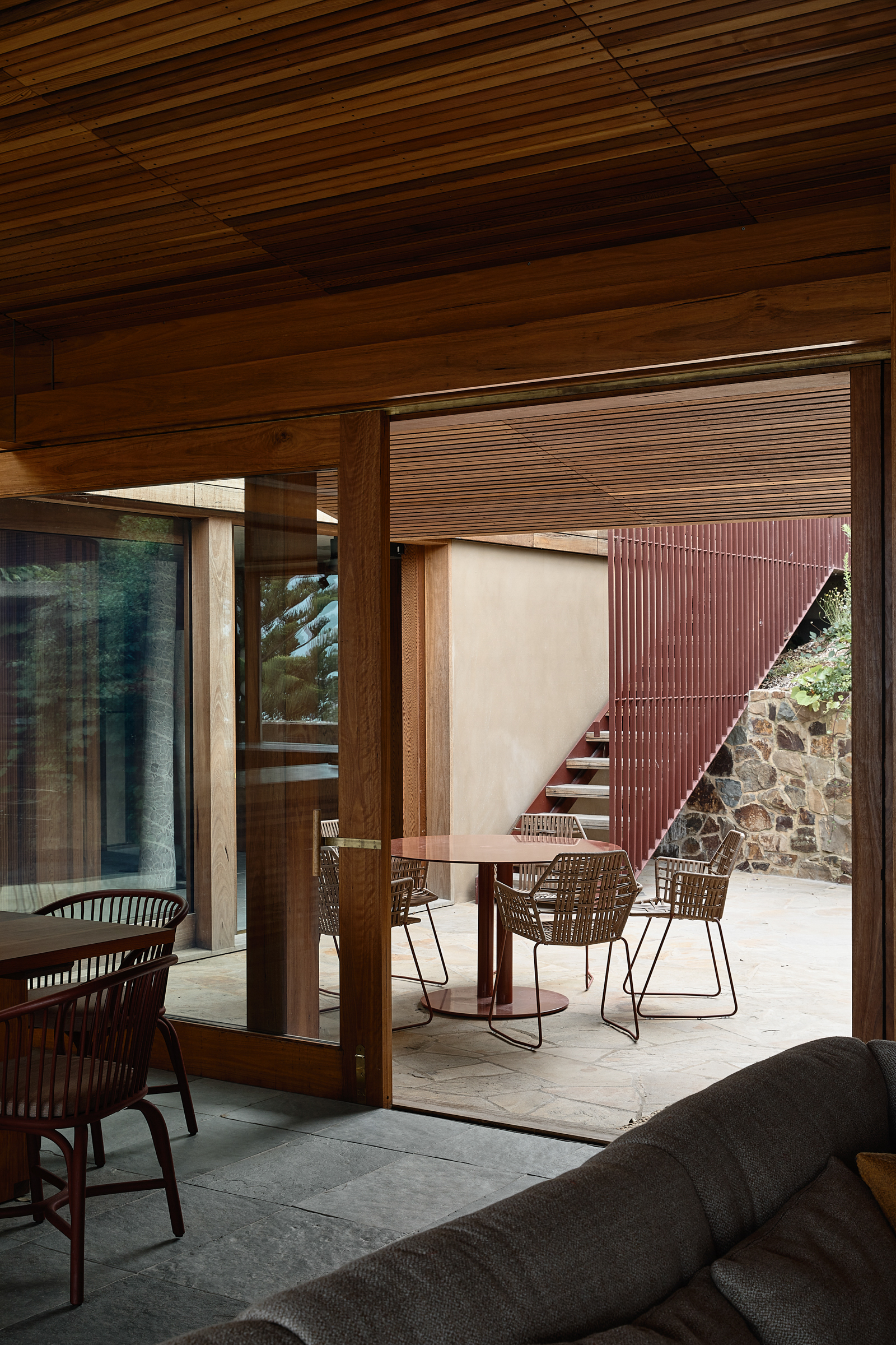 A view from the lounge room to an outdoor patio with a table and four chairs.