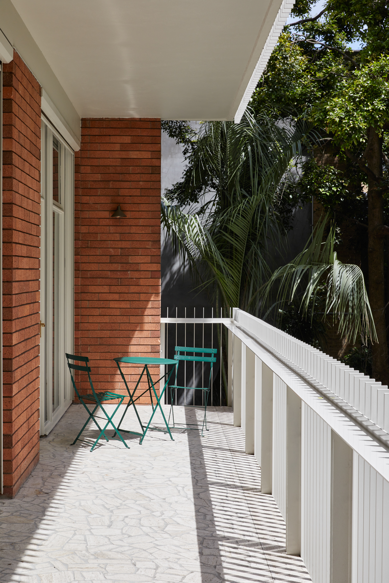 A balcony with a small table and chairs.