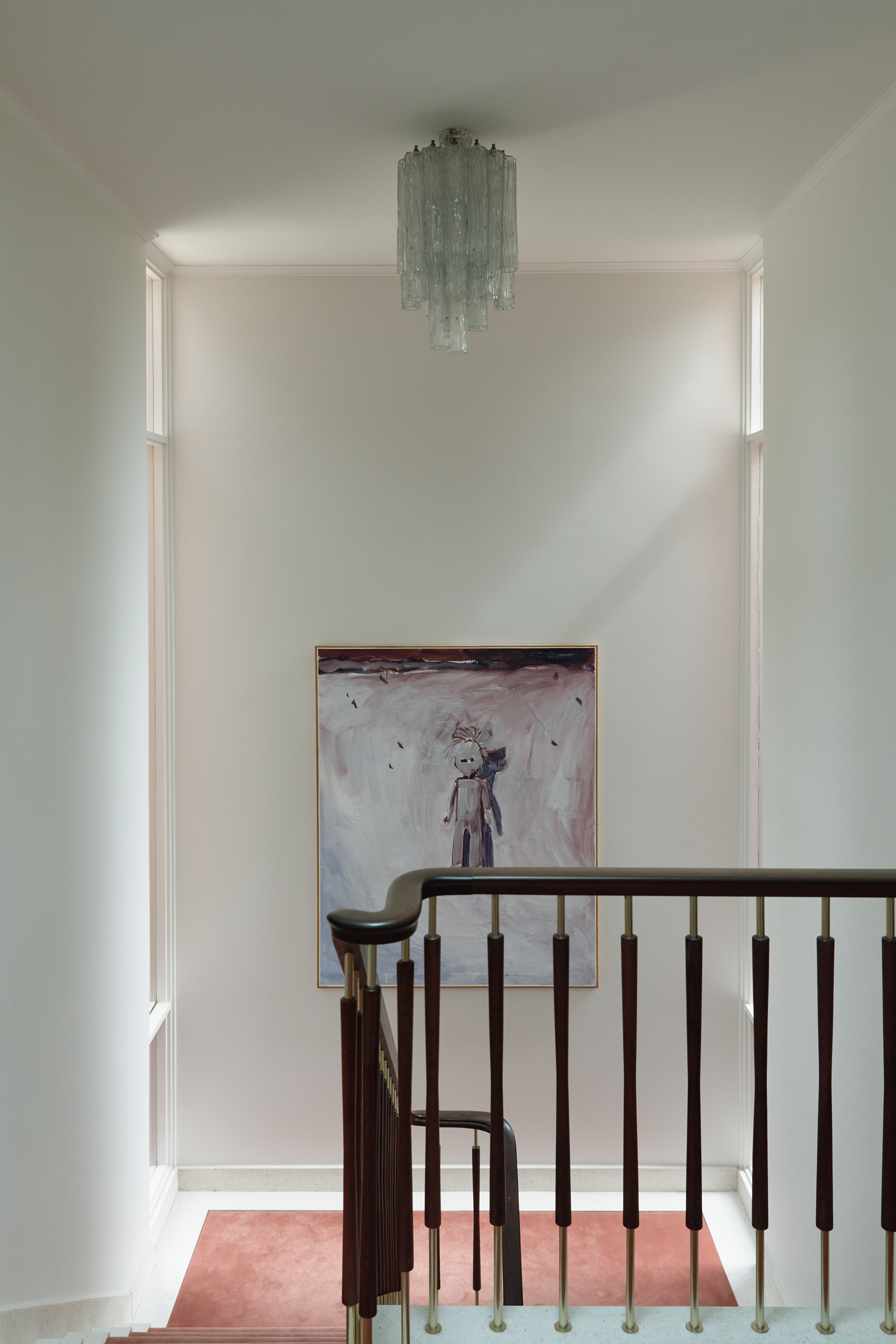 A stairway with a railing and a painting.