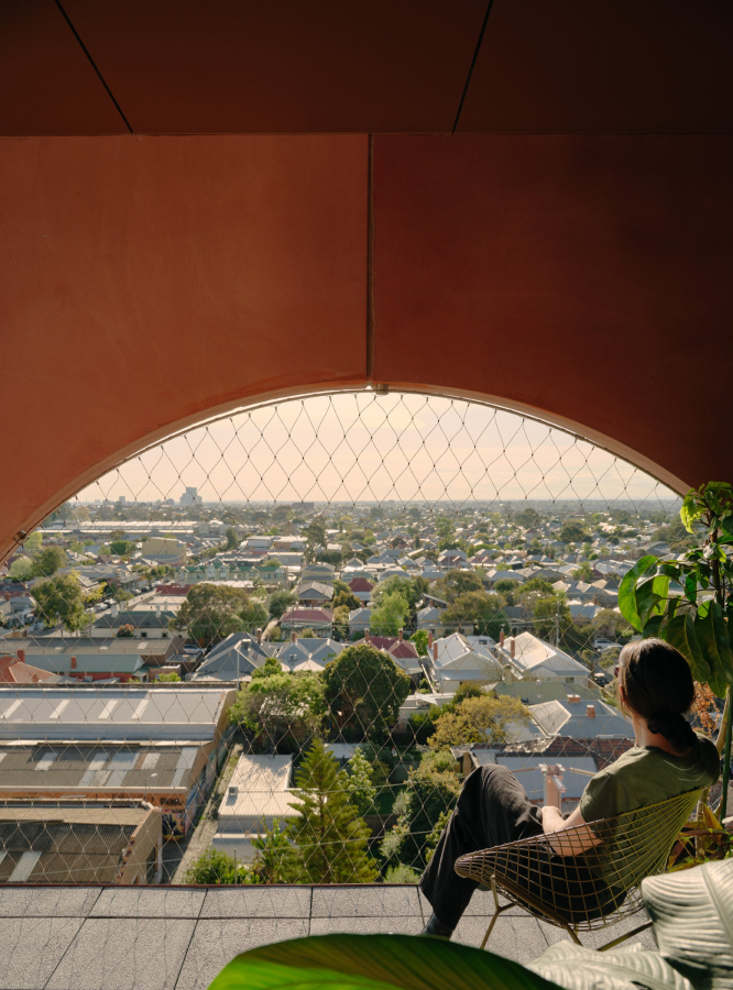 A woman sitting in a chair on a balcony.