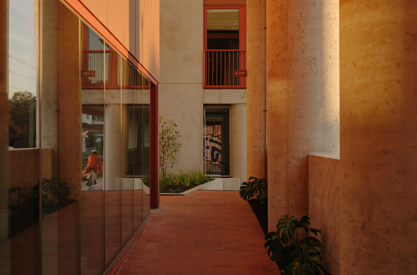 A walkway with columns leading to the entrance of a building.