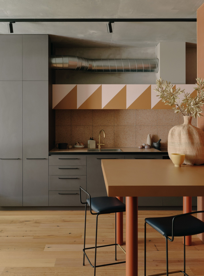 A kitchen with a table and two stools.