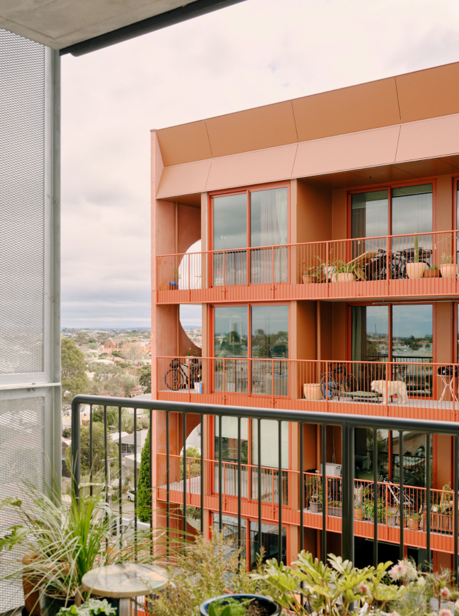 a view of a red multi-storey building from a balcony.