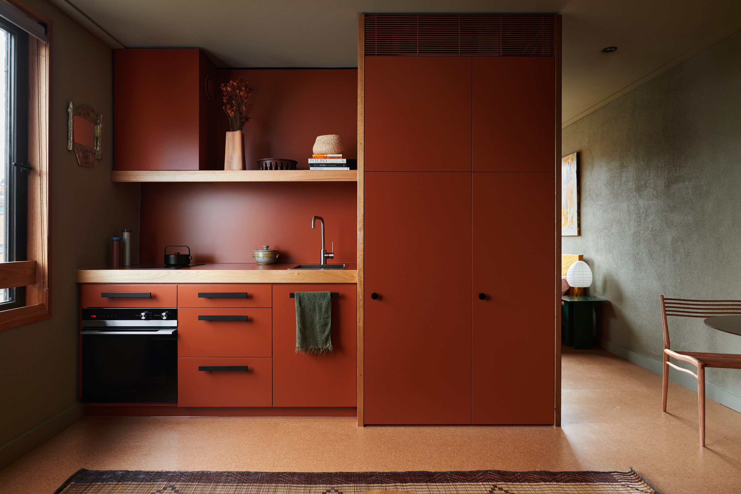 a deep red kitchen with a large cabinet and a sink