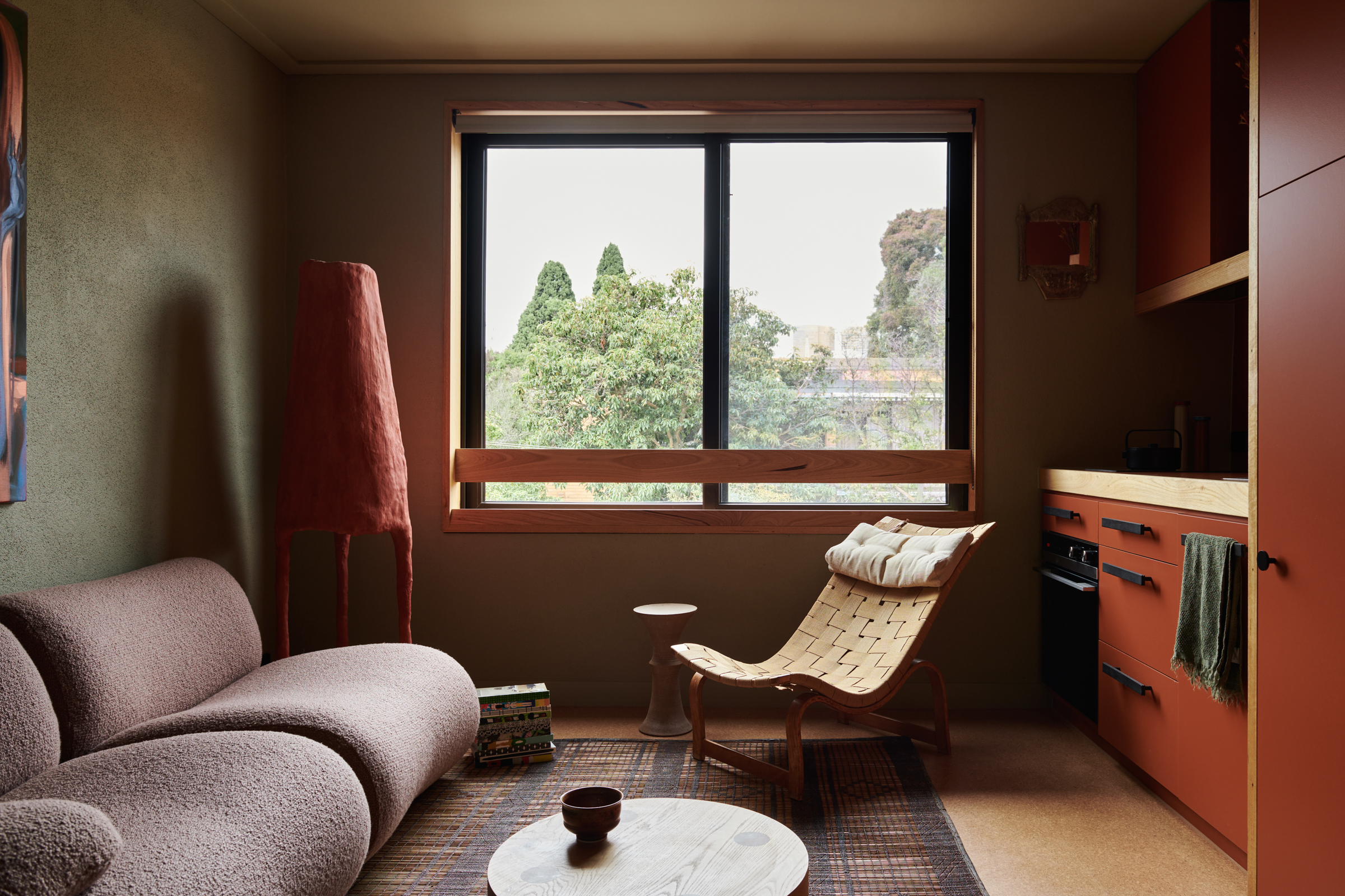 a living room and kitchen with a couch and a large window.